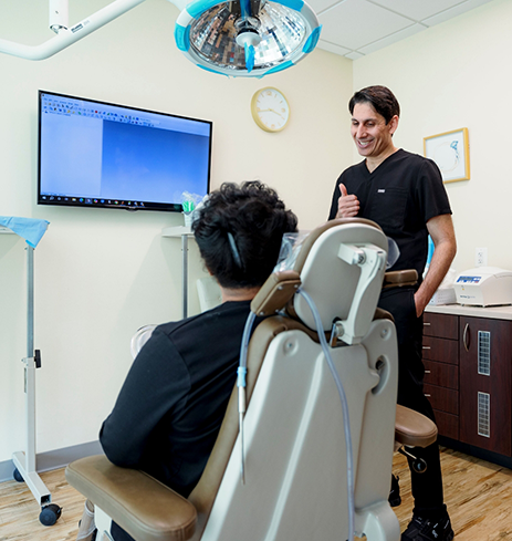 Oral surgeon holding a model tooth