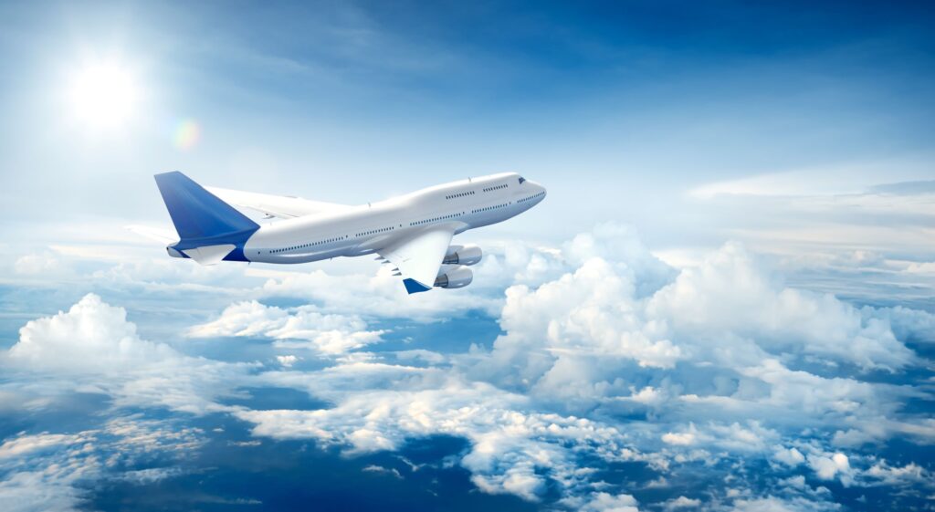 A white and blue airplane taking off into the clouds